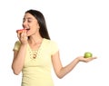 Concept of choice. Woman eating doughnut and holding apple on white background Royalty Free Stock Photo