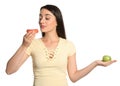 Concept of choice. Woman eating doughnut and holding apple on white background Royalty Free Stock Photo