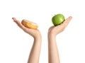 Concept of choice. Woman holding apple and doughnut on white background, closeup Royalty Free Stock Photo