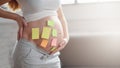 Concept of choosing baby name. cropped shot of pregnant woman with question marks on paper stickers on tummy Royalty Free Stock Photo