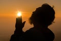 Concept Christian person worship or pray to God. Christian man silhouette with love, faith, devotion to God with sunrise sky