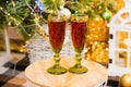 Concept of Christmas celebration and home comfort. Glasses with red wine close-up on a table under a Christmas tree Royalty Free Stock Photo