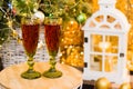 Concept of Christmas celebration and home comfort. Glasses with red wine close-up on a table under a Christmas tree Royalty Free Stock Photo