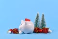 Concept for Christmas gift voucher giving and savings showing white piggy bank with red coupon surrounded by seasonalornaments Royalty Free Stock Photo