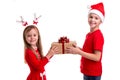 Concept: Christmas or Happy New Year holiday. Happy boy with santa hat on his head and a girl with deer horns, holding