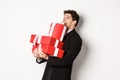 Concept of christmas holidays, celebration and lifestyle. Image of excited handsome man buying gifts for new year
