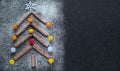 Concept of Christmas and New Year - Christmas tree made of cinnamon sticks on a black background with flour, decorated with a