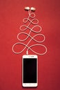 Concept. Christmas tree from smartphone and headphones.