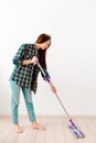 The concept of cleaning. Young Caucasian woman washing floors. There is a white wall in the background. Vertical. Copy space Royalty Free Stock Photo