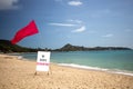 The concept of a closed beach, does not work, pandemic, the ban on travel and movement. there is a red flag and a sign Royalty Free Stock Photo