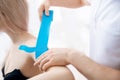 Concept closeup tape kinesio therapy. Doctor physiotherapist rehabilitation of sports pain of hand athlete woman