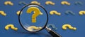 Closeup view of multiple question marks with a highlighted yellow one on a blue backdrop