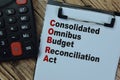 Concept of COBRA - Consolidated Omnibus Budget Reconciliation Act write on paperwork isolated on Wooden Table