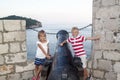 concept of cognitive recreation with children. happy and smiling boy with a girl standing near an old cannon on the city wall