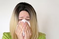 Sick woman sneezing and blowing her nose in a handkerchief