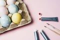 The concept of coloring Easter eggs in pastel watercolor colors. Paints and brushes for coloring eggs for Easter on pink Royalty Free Stock Photo