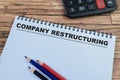 Concept of Company Restructuring write on book isolated on Wooden Table Royalty Free Stock Photo