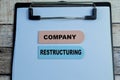 Concept of Company Restructuring write on sticky notes isolated on Wooden Table