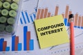 Concept of compound interest write on sticky notes with financial graphs isolated on Wooden Table Royalty Free Stock Photo