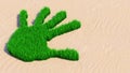 Green grass handprint on sand background