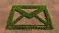 Green summer lawn grass symbol shape on brown soil or earth background, email sign Royalty Free Stock Photo