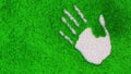 Ornamental gravel handprint on grass background