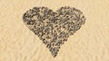Stones on beach sand handmade symbol shape, golden sandy background, heart sign Royalty Free Stock Photo