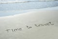 Time to travel handwritten text in sand on a beach with waves in an exotic island for adventure, summer Royalty Free Stock Photo