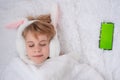 The concept of congratulations on Easter. Beautiful teenage girl sleeps sweetly. Baby with rabbit ears. Nearby lies a