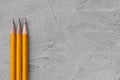 Concept of construction, three sharpened pencils on a background of gray plaster texture, space for text Royalty Free Stock Photo