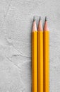 Concept of construction, three sharpened pencils on a background of gray plaster texture, space for text