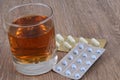 Glass of whiskey next to medicine blister packs close-up Royalty Free Stock Photo