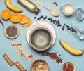 Concept of cooking healthy breakfast, berries, bananas, oranges, cereals, and milk, a vintage bowl on a blue background flat lay Royalty Free Stock Photo