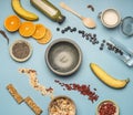 Concept of cooking a healthy breakfast, berries, bananas, oranges, cereals, and milk, a vintage bowl on a blue background flat lay Royalty Free Stock Photo