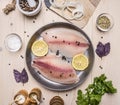 concept cooking tilapia fillets with lemon on vintage pan with herbs, vegetables and spices on wooden rustic background top view