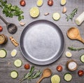 Concept cooking vegetarian food ingredients laid out around the pan with a knife spices space for text on rustic wooden backgr Royalty Free Stock Photo