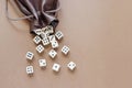 Set of white gaming dice rolled out of leather bag on brown background. Royalty Free Stock Photo