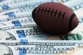 The concept of corruption or sports betting. Close-up of a symbol of rugby or American football on a background of hundred dollar Royalty Free Stock Photo