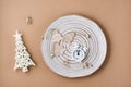 Concept Countdown on Christmas night. Table setting. Alarm clock and Christmas trees on a plate on a beige background. Top view Royalty Free Stock Photo