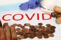 The concept of counting pennies due to Covid with loose and wrapped coins and the word COVID