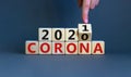 Concept of covid-19 pandemic in 2021. Male hand flips a wooden cube and changes the inscription `corona 2020` to `corona 2021` Royalty Free Stock Photo