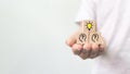 Hand holding wooden cube block with light bulb and head human symbol icon