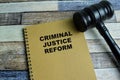 Concept of Criminal Justice Reform write on book with gavel isolated on Wooden Table