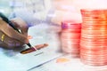 Concept of currency trading. Stack of coins and a hand holding is examining a technical chart of financial instrument Royalty Free Stock Photo