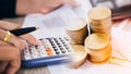 Concept of currency trading. Stack of coins and a hand holding is examining a technical chart of financial instrument Royalty Free Stock Photo