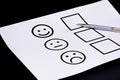 The concept of a customer satisfaction survey and a questionnaire. Provide feedback via a multi-choice form. paper and emoticon Royalty Free Stock Photo