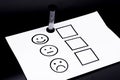 The concept of a customer satisfaction survey and a questionnaire. Provide feedback via a multi-choice form. paper and emoticon