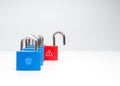 Concept of cybersecurity risk and data breach with a row of locked blue padlocks and one red unlocked padlock with warning symbol Royalty Free Stock Photo