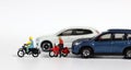 Miniature people and miniature car. Miniature motorcycle messenger between miniature cars. Royalty Free Stock Photo