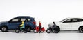 Miniature people and miniature car. Miniature motorcycle messenger between miniature cars. Royalty Free Stock Photo